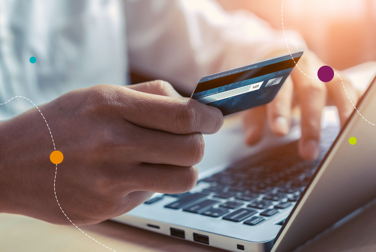 Person holding credit card while on computer